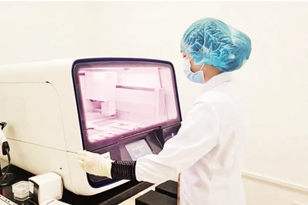 Giám định viên của Trung tâm Giám định ADN phân tích mẫu hài cốt liệt sĩ. (Ảnh HOÀNG GIANG)