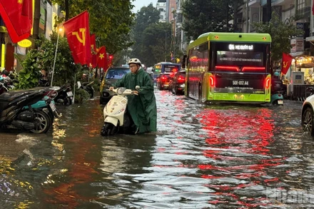 Mưa lớn cùng lúc với triều cường dâng cao nhiều khu vực ở Thành phố Hồ Chí Minh khiến người dân di chuyển khó khăn.