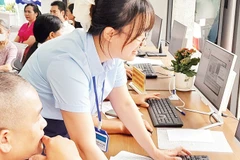 Cán bộ Điểm phục vụ Hành chính công phường Tây Hồ hướng dẫn người dân làm thủ tục hành chính trên môi trường mạng.
