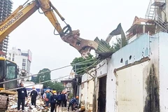 Lực lượng chức năng thực hiện cưỡng chế giải phóng mặt bằng tại khu vực thuộc dự án đường Vành đai 1, địa phận phường Ô Chợ Dừa, Hà Nội).