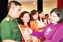 Đồng chí Văn Thị Bạch Tuyết, Phó Bí thư Thành ủy Thành phố Hồ Chí Minh tặng Bằng khen cho các tập thể có thành tích xuất sắc trong phong trào thi đua “Dân vận khéo” năm 2025. (Ảnh QUỐC THANH)