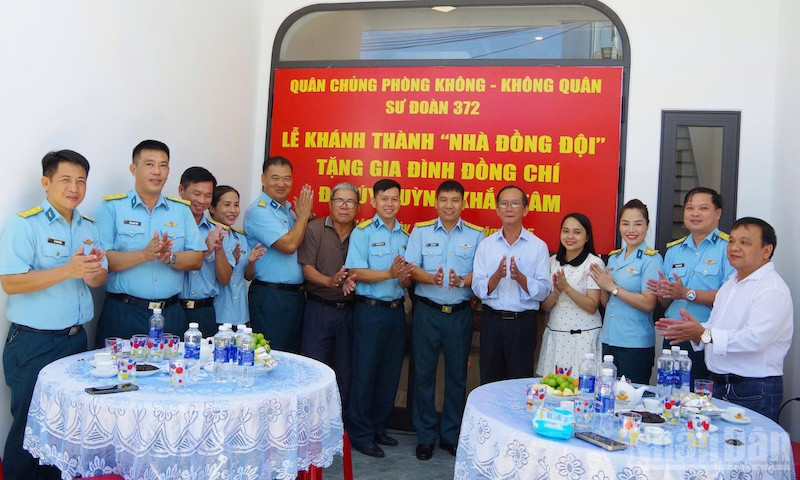 Các đại biểu dự buổi khánh thành và bàn giao “Nhà đồng đội” chụp ảnh lưu niệm với gia đình Đại úy Huỳnh Khắc Tâm. (Ảnh: VĂN TÂM)