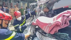 Lực lượng cứu nạn đưa thi thể nạn nhân ra ngoài. (Ảnh: TTXVN)
