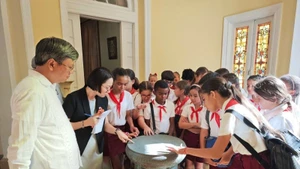 Các em học sinh thích thú khám phá mô hình Trống Đồng-biểu tượng của văn hóa Việt Nam. (Ảnh: Đại sứ quán Việt Nam tại Cuba)