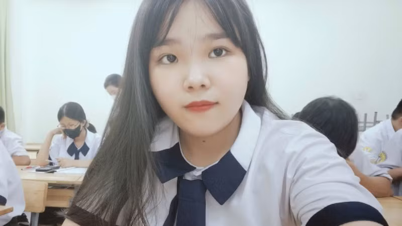 Trong bộ đồng phục trắng giản dị, Như Quỳnh ngồi giữa các bạn nhỏ tuổi hơn, bước trên hành trình mới.