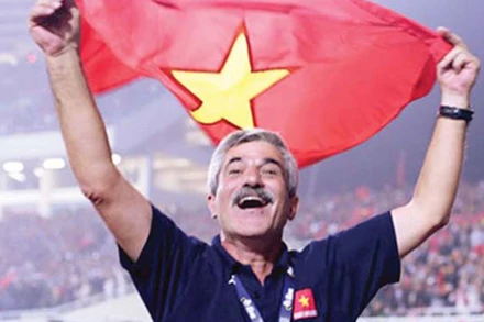 Huấn luyện viên Henrique Calisto ăn mừng cùng quốc kỳ Việt Nam trên sân Mỹ Đình sau khi giành chức vô địch AFF Cup 2008. (Ảnh: VFF)