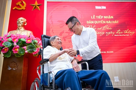 Nhạc sĩ Phạm Tuyên và Tổng Biên tập Báo Nhân Dân Lê Quốc Minh tại buổi lễ tiếp nhận. (Ảnh: THÀNH ĐẠT)