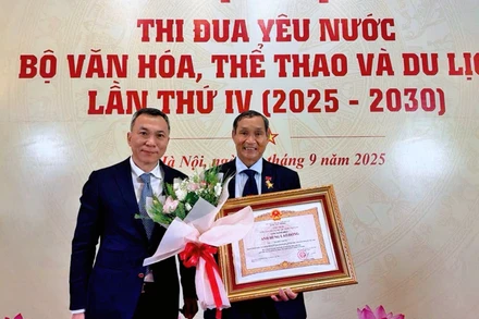 Chủ tịch Liên đoàn Bóng đá Việt Nam Trần Quốc Tuấn chúc mừng huấn luyện viên Mai Đức Chung được trao danh hiệu Anh hùng Lao động. 