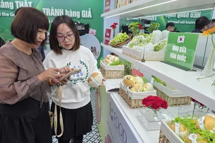 Chuyên viên của Cục Quản lý và Phát triển thị trường trong nước hướng dẫn khách tham quan nhận diện sản phẩm quả lê Hàn Quốc.