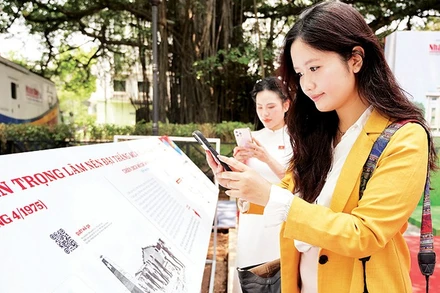 Các bạn trẻ quét mã QR xem thông tin các trận đánh tại triển lãm tương tác do Báo Nhân Dân tổ chức dịp kỷ niệm 50 năm Ngày Giải phóng miền nam, thống nhất đất nước. Ảnh | THẾ ĐẠI