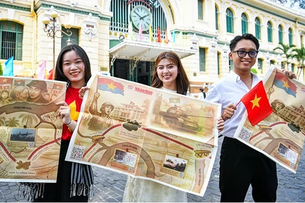 Các bạn trẻ hào hứng với phụ san đặc biệt của Báo Nhân Dân tuyên truyền kỷ niệm 50 năm Ngày Giải phóng miền nam, thống nhất đất nước.