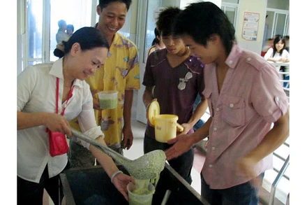 Chị Hồ Phương Thảo phát cháo cho bệnh nhân nghèo.