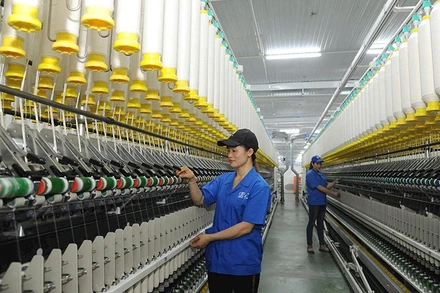 Công nhân Công ty TNHH một thành viên Dệt 8-3 vận hành dây chuyền sản xuất sợi.