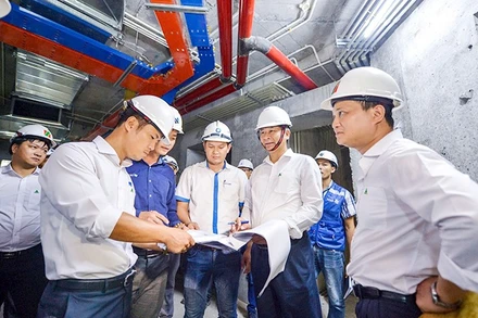 Cán bộ Công ty cổ phần Đầu tư Phát triển Nhà Constrexim kiểm tra tiến độ công trình. Ảnh trong bài | THÀNH ĐẠT