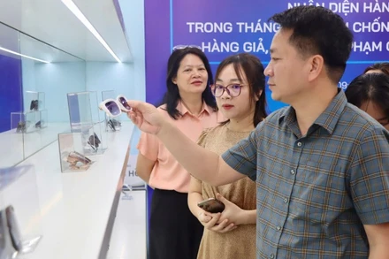 Phó Cục trưởng Quản lý và Phát triển thị trường trong nước (Bộ Công thương) Nguyễn Thanh Bình hướng dẫn người tham quan nhận diện kính mắt hàng giả.