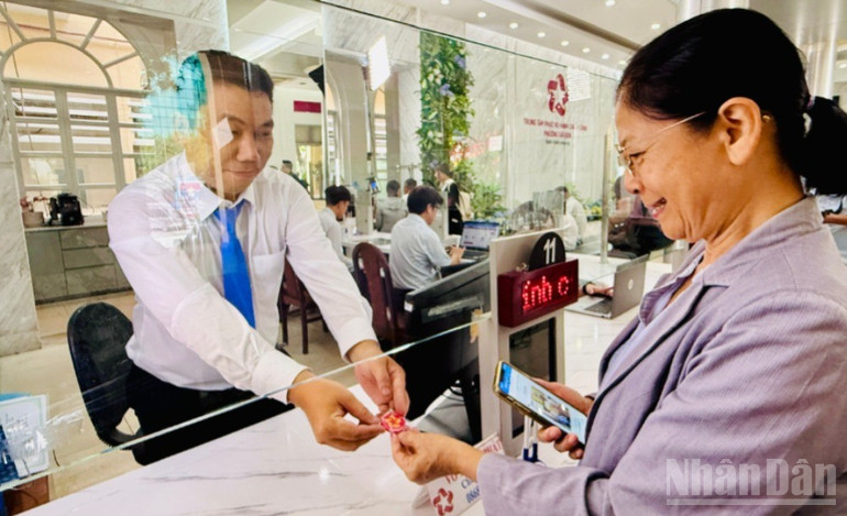 Bà Phùng Thị Nguyệt được cán bộ phường Sài Gòn tặng món quà lưu niệm nhỏ trong ngày đầu tiên vận hành mô hình chính quyền địa phương 2 cấp. (Ảnh: VƯƠNG LÊ) ndo_br_z6760070798108-0bd8648fde5d7069ffde6706565ffa89-7574.jpg