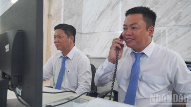Chuyên viên trả lời thắc mắc khi người dân gọi điện tới hỏi dịch vụ công tại phường Sài Gòn. (Ảnh: THẾ ANH ) ndo_br_4-6209-489.jpg