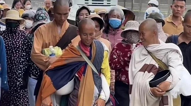 Ông Minh Tuệ (hàng đầu giữa) trong hành trình đi bộ từ Nam ra Bắc luôn thu hút sự hiếu kỳ của nhiều người. (Ảnh: VN/TTXVN)