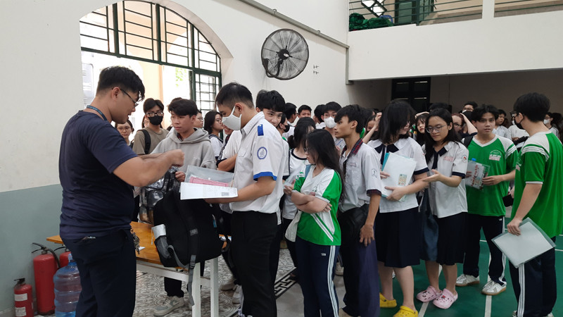 Các thí sinh làm thủ tục gửi đồ tại khu vực gửi đồ ở điểm thi Trường trung học phổ thông Lê Quý Đôn.