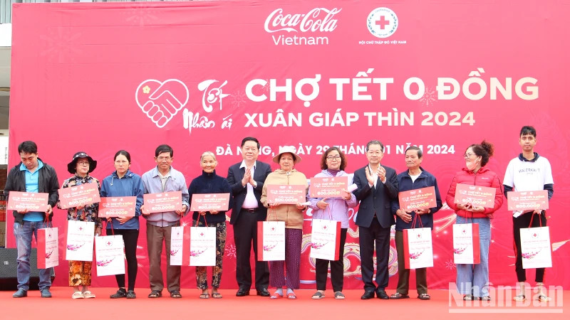 Đồng chí Nguyễn Trọng Nghĩa và Nguyễn Văn Quảng trao quà tặng các hộ nghèo tại chương trình "Chợ Tết 0 đồng".