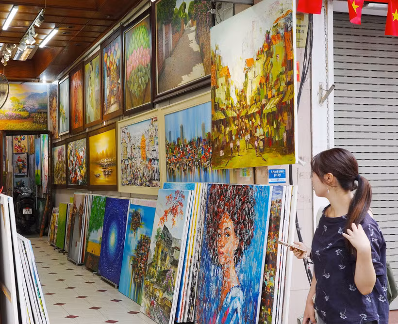 Tranh sao chép phong cách, nội dung sáng tác của nhiều họa sĩ tên tuổi trong và ngoài nước được bày bán công khai trên một số tuyến phố Hà Nội. (Ảnh Minh Lê) 