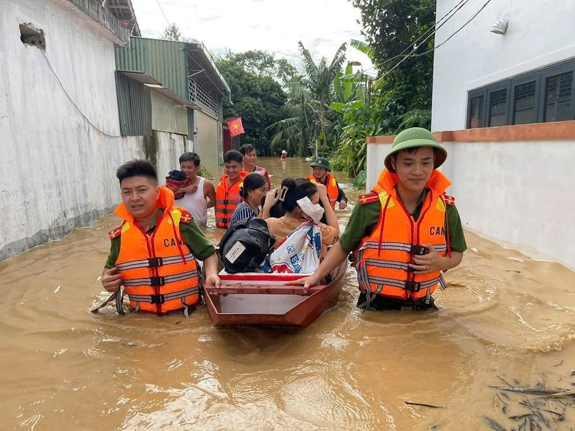 Công an tỉnh Nghệ An hỗ trợ di dời người dân vùng bị ngập lũ do bão số 3 đến nơi an toàn. (Ảnh PHẠM THỦY)