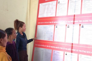 Cử tri khu vực bỏ phiếu số 17 (bản Nước Đắng, xã Trường Sơn, tỉnh Quảng Trị) tìm hiểu lý lịch của các ứng cử đại biểu Quốc hội và đại biểu Hội đồng nhân dân các cấp nhiệm kỳ 2026-2031 để chuẩn bị bỏ phiếu vào ngày 8/3 tới. (Ảnh: HƯƠNG GIANG)