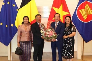 Đại sứ Kingphokeo Phommahaxay (trái) tặng hoa cho Đại sứ Nguyễn Văn Thảo. (Ảnh: HƯƠNG GIANG/TTXVN)