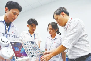 Giảng viên Khoa công nghệ điện tử Trường đại học Công nghiệp Thành phố Hồ Chí Minh hướng dẫn sinh viên học tập, nghiên cứu tại Phòng thí nghiệm IoT and AI. (Ảnh: THANH VŨ)