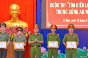 Đại tá Trần Văn Thi, Phó Giám đốc Công an tỉnh Cà Mau (đứng giữa) trao Giấy khen cho nhóm tác giả đạt giải Nhất cấp tỉnh Cuộc thi tìm hiểu Luật Dữ liệu Công an nhân dân.