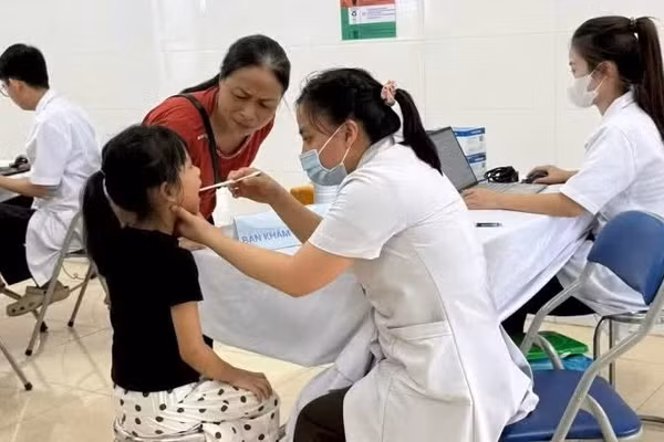 Các y, bác sĩ Trạm Y tế xã Ba Vì (thành phố Hà Nội) khám sức khỏe cho trẻ em trên địa bàn. (Ảnh: Báo Nhân Dân)