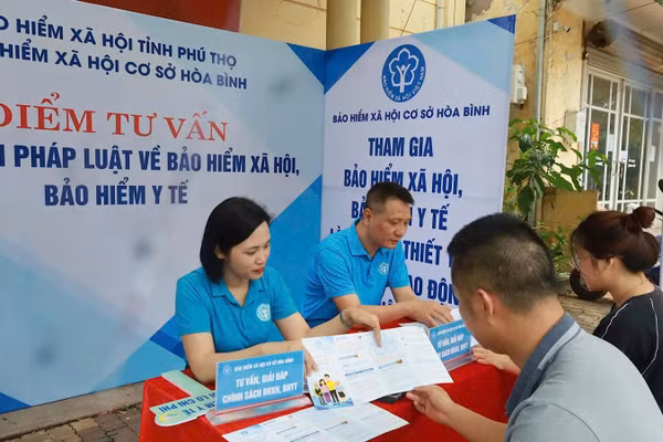 Cán bộ cơ quan Bảo hiểm xã hội cơ sở Hòa Bình (Phú Thọ) tư vấn chính sách bảo hiểm xã hội, bảo hiểm y tế cho người dân. (Ảnh: nhandan.vn)