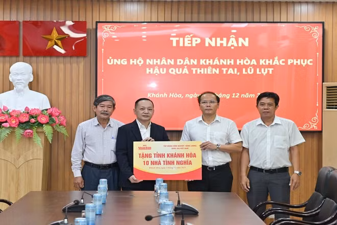 Đồng chí Nguyễn Khắc Hà (thứ hai từ phải sang) tiếp nhận hỗ trợ từ Báo Nhân Dân. (Ảnh: VĨNH THÀNH) 