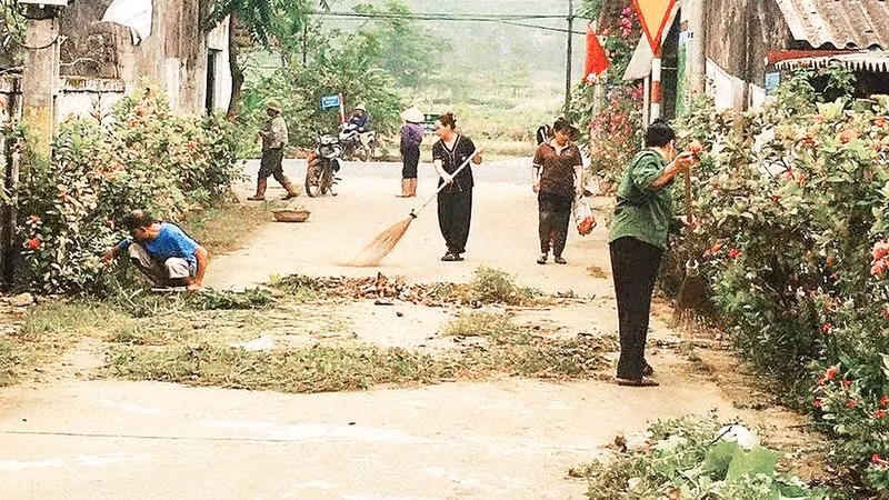 Người dân xã Suối Hai cùng nhau làm sạch đường làng ngõ xóm (Ảnh HỒNG LÊ)