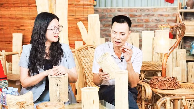 Anh Nguyễn Trọng Điểm giới thiệu chiếc đèn đu đủ với Phó Chủ tịch Ủy ban nhân dân xã Phú Nghĩa Trần Thị Thu Hằng.