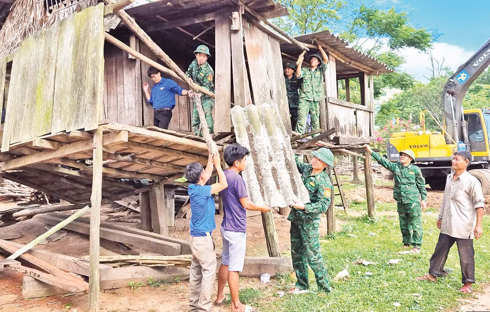 Bộ đội Biên phòng cùng thanh niên tình nguyện và các hộ dân ở xã biên giới Dân Hóa, huyện Minh Hóa tháo dỡ các mái nhà dột nát để làm nhà mới.