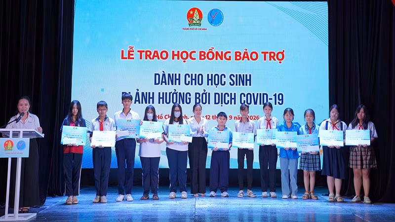 Đại diện Ban tổ chức trao học bổng bảo trợ dành cho các em học sinh bị ảnh hưởng đại dịch Covid-19. (Ảnh: CTV)