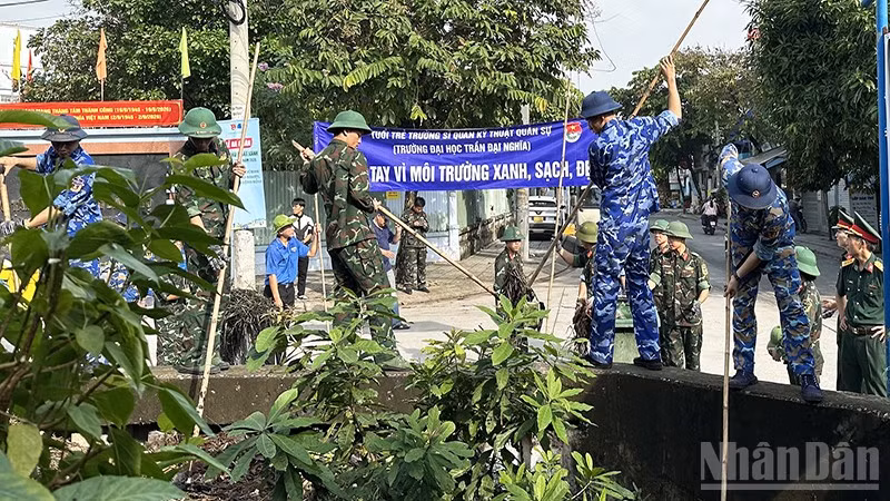 Thanh niên lực lượng vũ trang tham gia dọn vệ sinh, khơi thông dòng chảy rạch Nhà Nuôi. (Ảnh: HOÀNG LIÊM)
