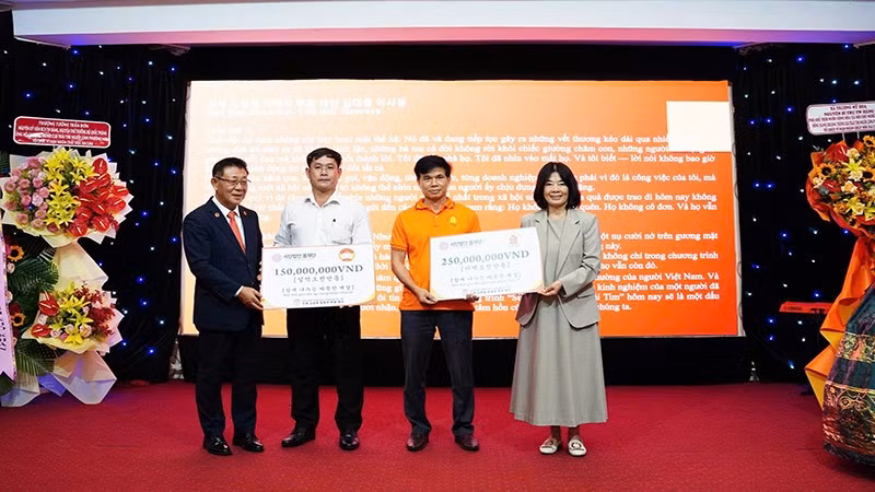 Đại diện hai tổ chức Bom Foundation và Hoavava trao tặng tiền hỗ trợ. 