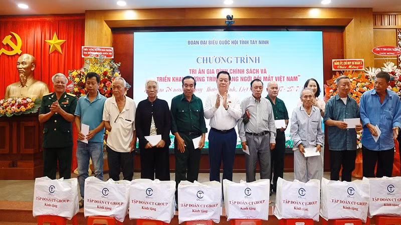 Đồng chí Nguyễn Trọng Nghĩa trao quà và hoa tri ân các gia đình chính sách.