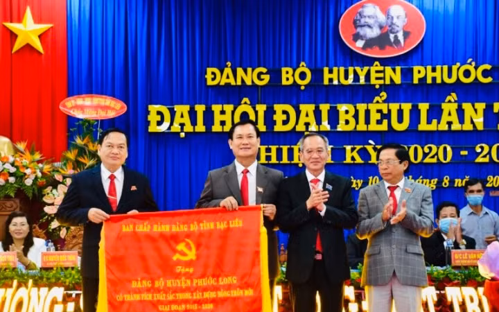 Đồng chí Lữ Văn Hùng, Bí thư Tỉnh ủy (thứ hai từ phải sang) trao Cờ của Ban Chấp hành Đảng bộ tỉnh cho Đảng bộ huyện Phước Long, vì có thành tích xuất sắc trong xây dựng nông thôn mới.