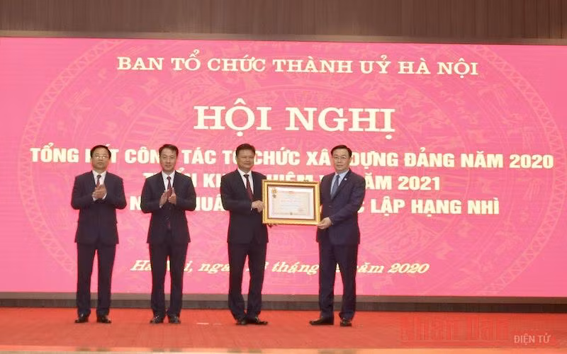 Đồng chí Vương Đình Huệ, Ủy viên Bộ Chính trị, Bí thư Thành ủy Hà Nội trao Huân chương Độc lập hạng Nhì cho Ban Tổ chức Thành ủy Hà Nội. (Ảnh: Duy Linh)