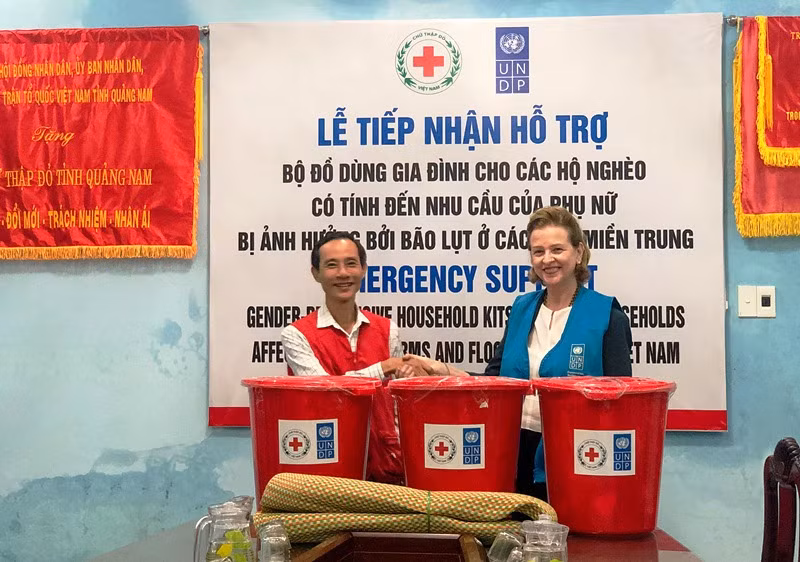 Bà Caitlin Wiesen trao đồ hỗ trợ cho người dân vùng bị ảnh hưởng bão lụt.