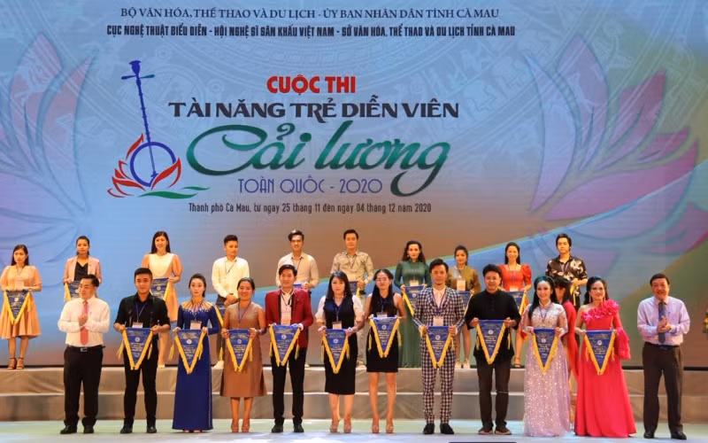 Đại diện Ban Tổ chức trao cờ lưu niệm cho những thí sinh dự thi. (Ảnh: Cục NTBD)