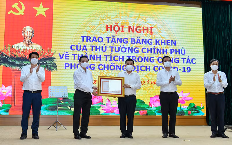 Chủ tịch UBND thành phố Chu Ngọc Anh trao Bằng khen của Thủ tướng Chính phủ cho nhân dân và cán bộ huyện Đông Anh. Ảnh: Duy Linh