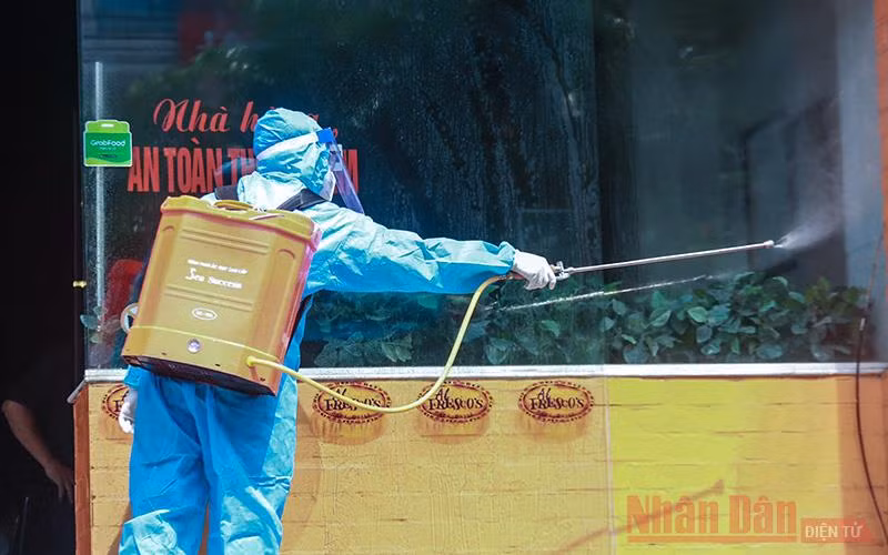  Lực lượng chức chức năng quận Cầu Giấy đã tiến hành phong tỏa, phun khử trùng bên trong và chung quanh quán pizza trên phố Trần Thái Tông. (Ảnh: HÀ NAM)