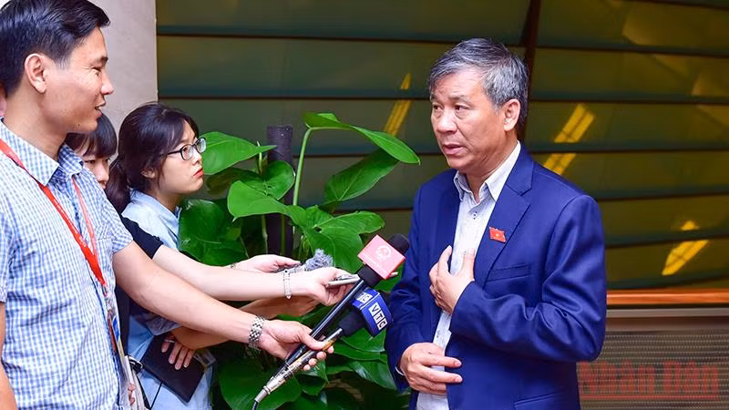 Đại biểu Quốc hội Nguyễn Anh Trí trao đổi với báo chí bên hành lang Quốc hội. Ảnh: DUY LINH