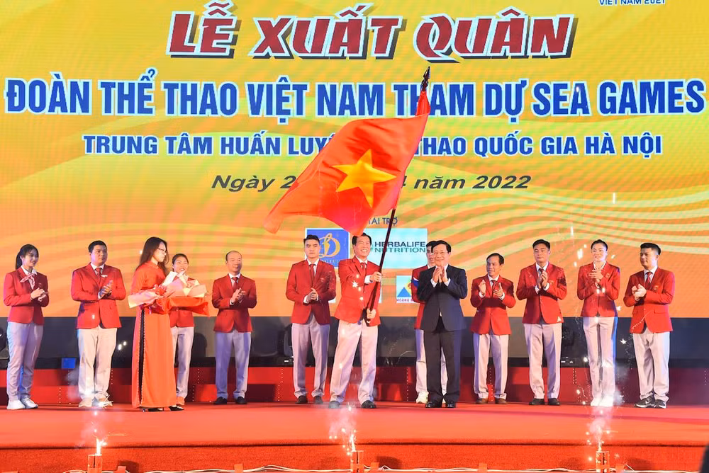 Trưởng đoàn thể thao Việt Nam dự SEA Games 31 Trần Đức Phấn nhận lá cờ Tổ quốc từ Phó Thủ tướng Thường trực Chính phủ Phạm Bình Minh. (Ảnh: THỦY NGUYÊN)
