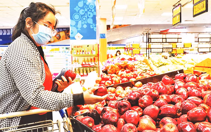 Người tiêu dùng chọn mua trái cây tại một siêu thị Co.opmart ở TP Hồ Chí Minh.