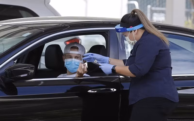 Nhân viên y tế thu thập thông tin của người dân tại một trung tâm xét nghiệm Covid-19 ở California, Mỹ, ngày 21-7. (Ảnh: AP)